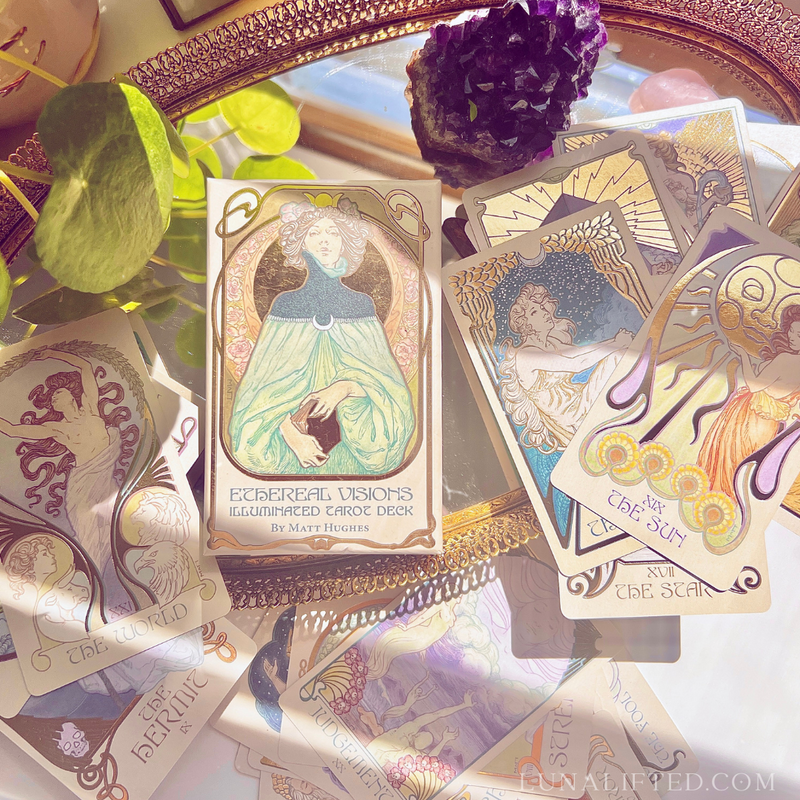 A tarot spread laid out on a table, with cards like The Empress and The Chariot visible, symbolizing empowerment and action.